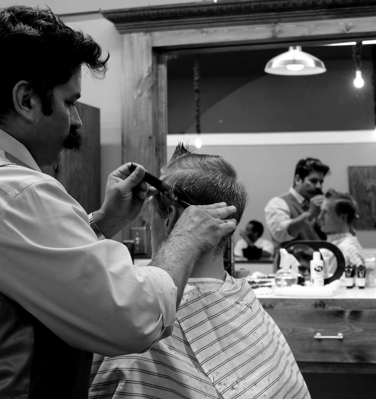 Barber cutting a customer’s hair with comb and scissors