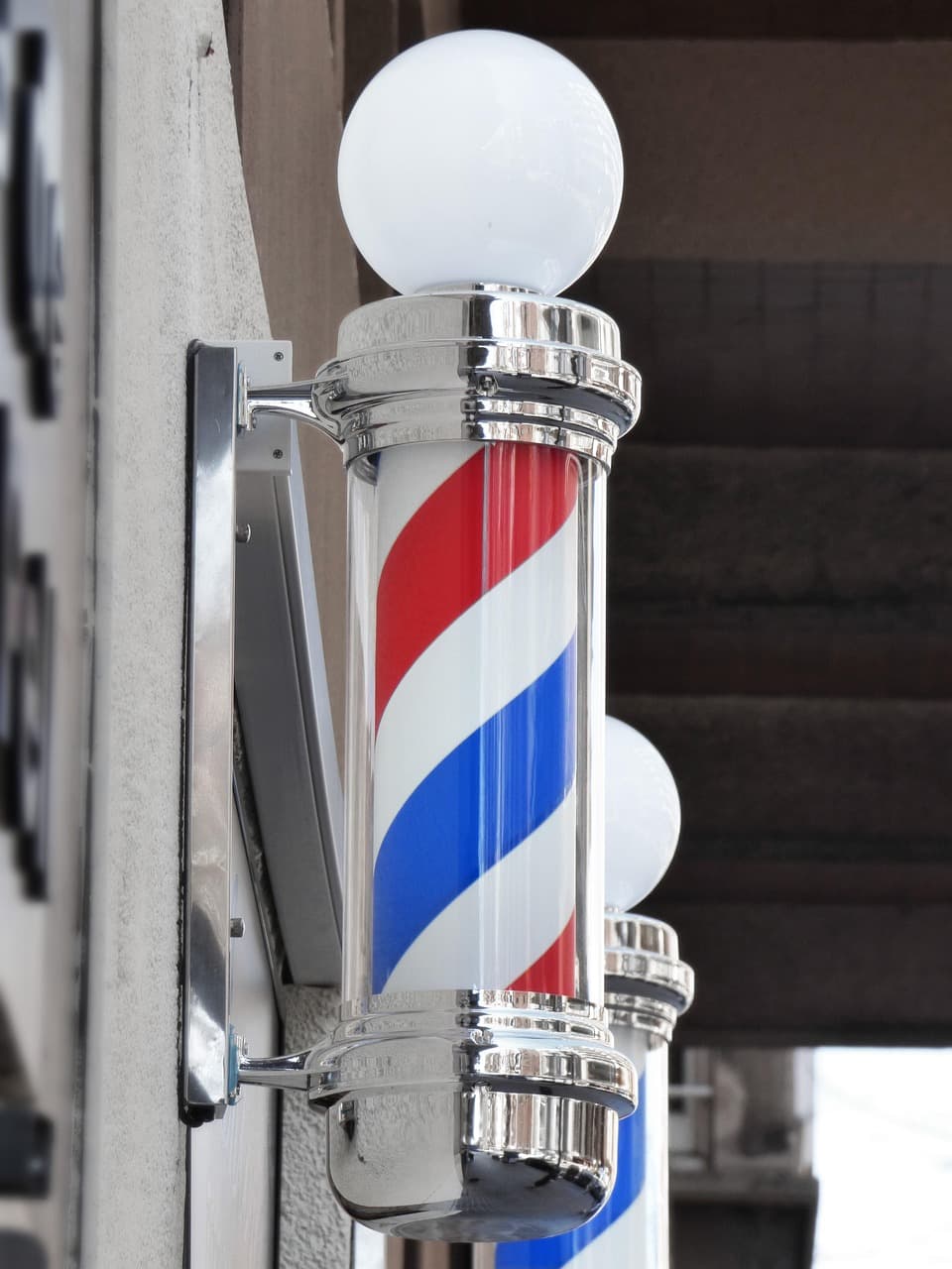 A red, white and blue barber pole on a shop front
