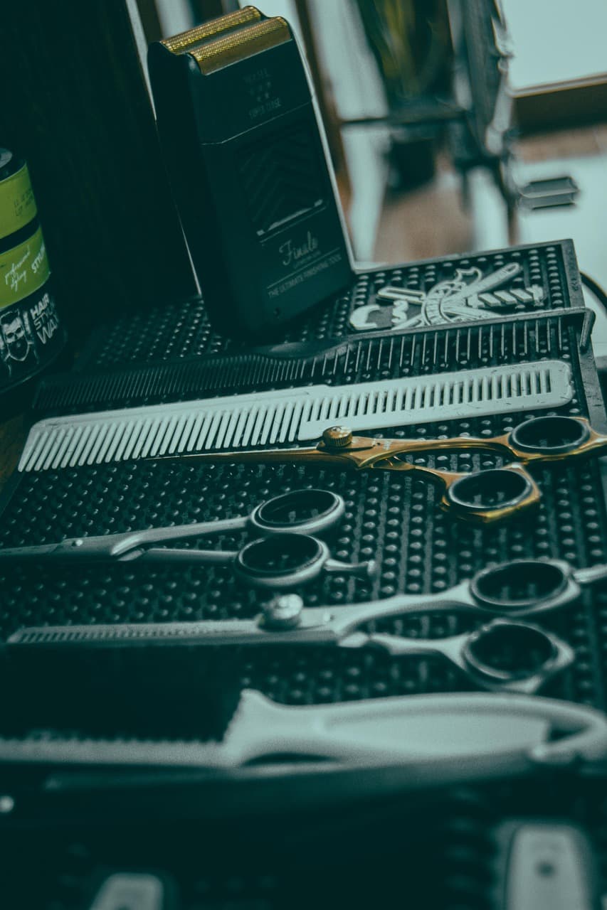 Scissors, combs and clippers laid out on a barber’s mat